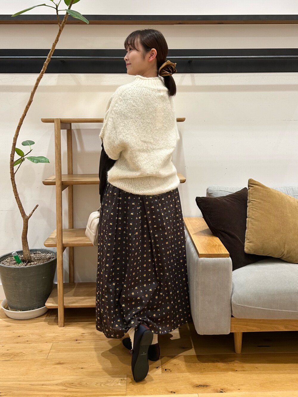 ホワイト系のニット/セーター、ブラウン系のTシャツ/カットソー、グレー系のボストンバッグを着用したレディースの秋コーディネートの5枚目の写真