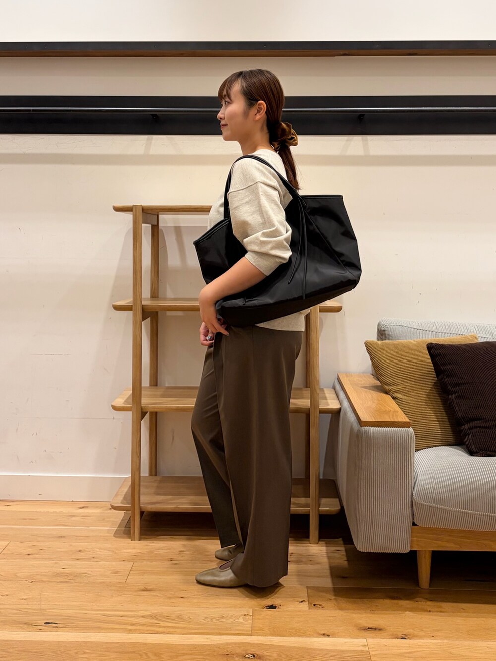 ブラック系のトートバッグ、ベージュ系のその他トップス、ブラウン系のスリッポンを着用したレディースの秋コーディネートの4枚目の写真