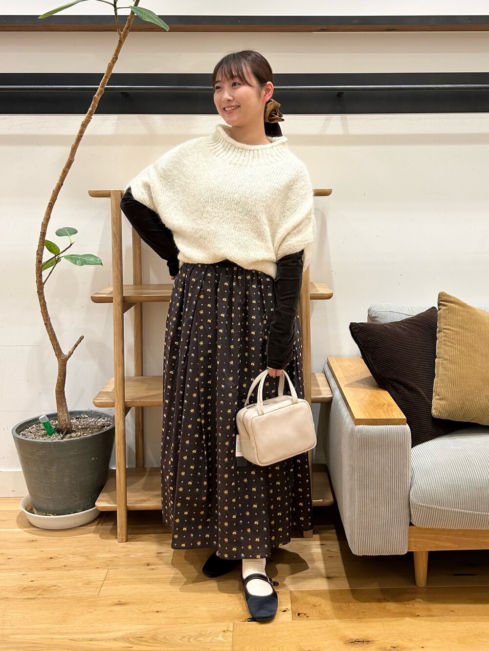 ホワイト系のニット/セーター、ブラウン系のTシャツ/カットソー、グレー系のボストンバッグを着用したレディースの秋コーディネートの6枚目の写真