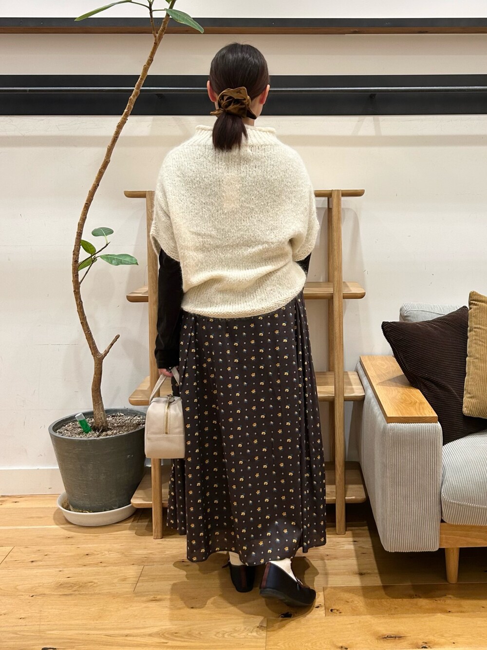 ホワイト系のニット/セーター、ブラウン系のTシャツ/カットソー、グレー系のボストンバッグを着用したレディースの秋コーディネートの3枚目の写真