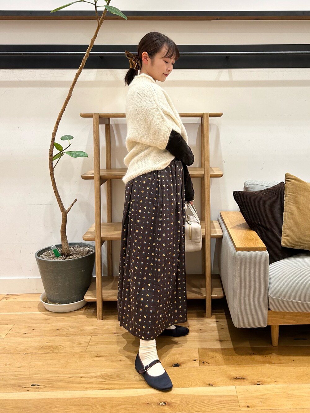 ホワイト系のニット/セーター、ブラウン系のTシャツ/カットソー、グレー系のボストンバッグを着用したレディースの秋コーディネートの4枚目の写真