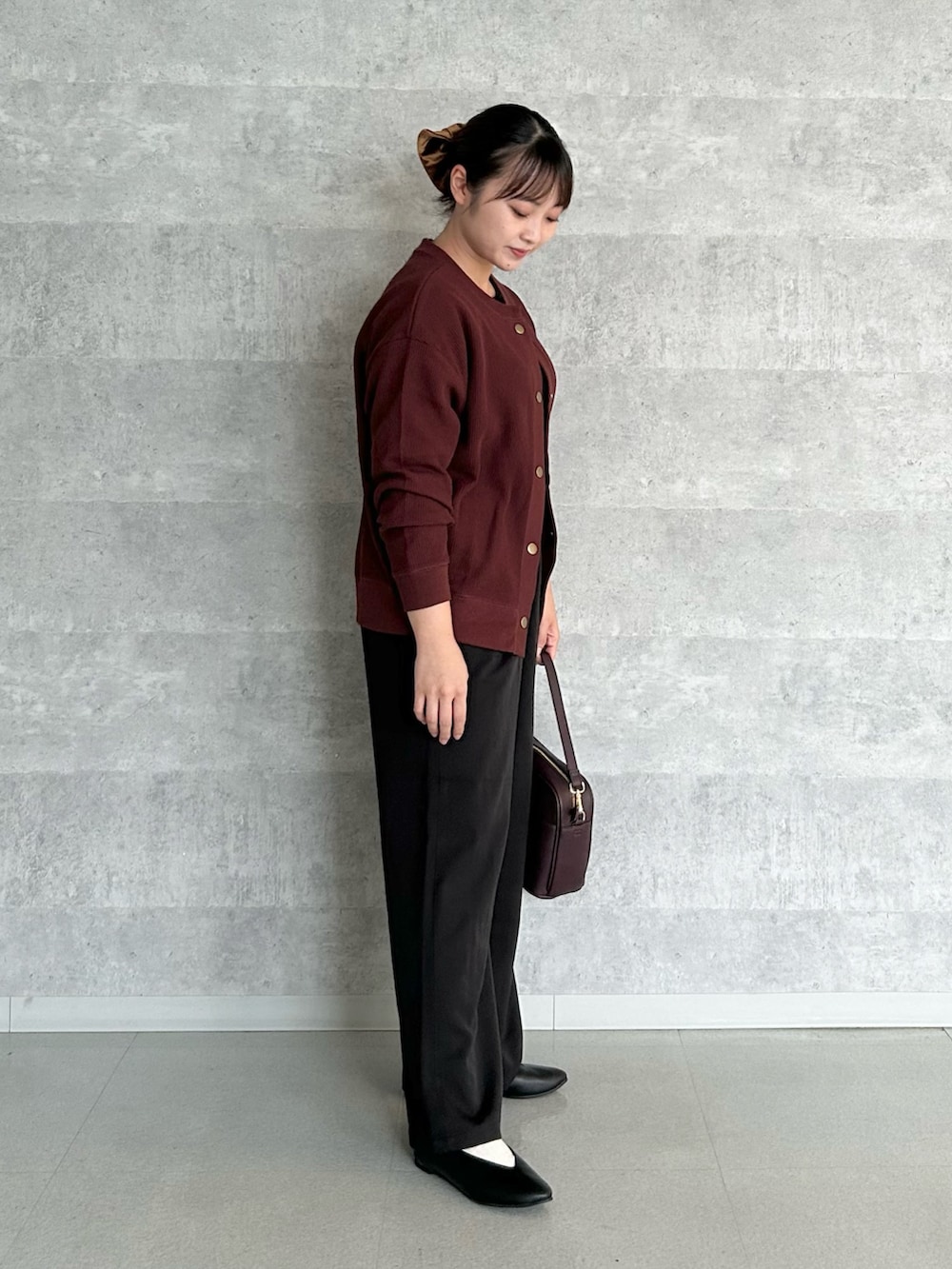 レッド系のショルダーバッグ、ブラック系のその他パンツ、ブラック系のパンプスを着用したレディースの秋コーディネートの2枚目の写真