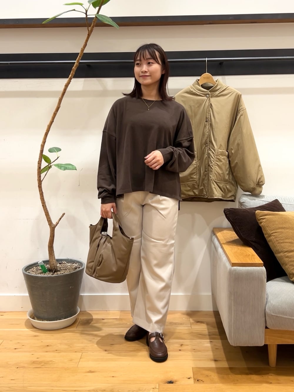 ブラウン系のTシャツ/カットソー、ベージュ系のブルゾン、グレー系のその他パンツを着用したレディースの秋コーディネートの2枚目の写真
