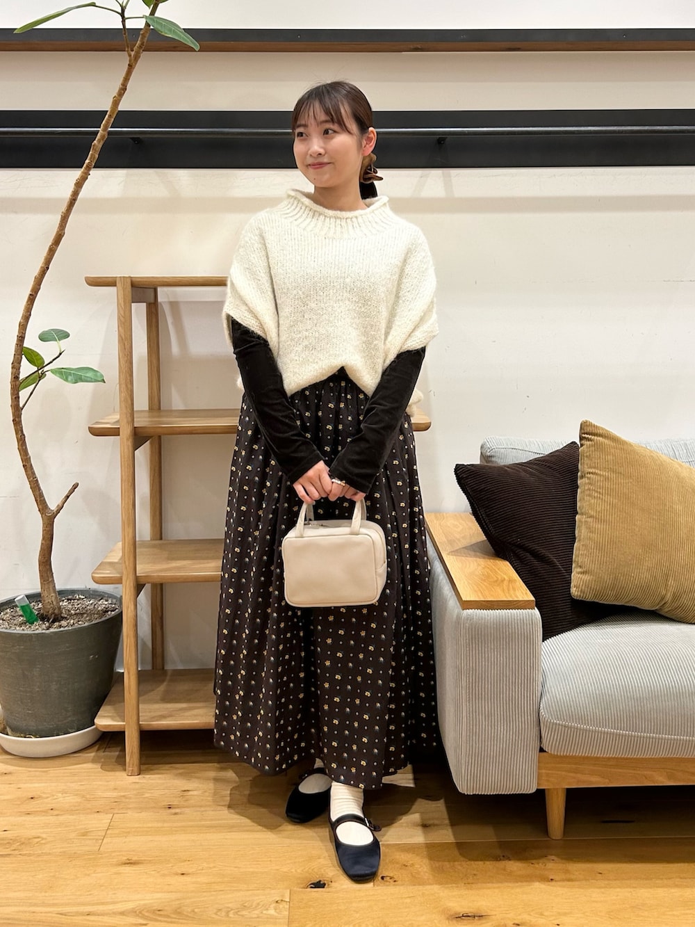 ホワイト系のニット/セーター、ブラウン系のTシャツ/カットソー、グレー系のボストンバッグを着用したレディースの秋コーディネートの7枚目の写真