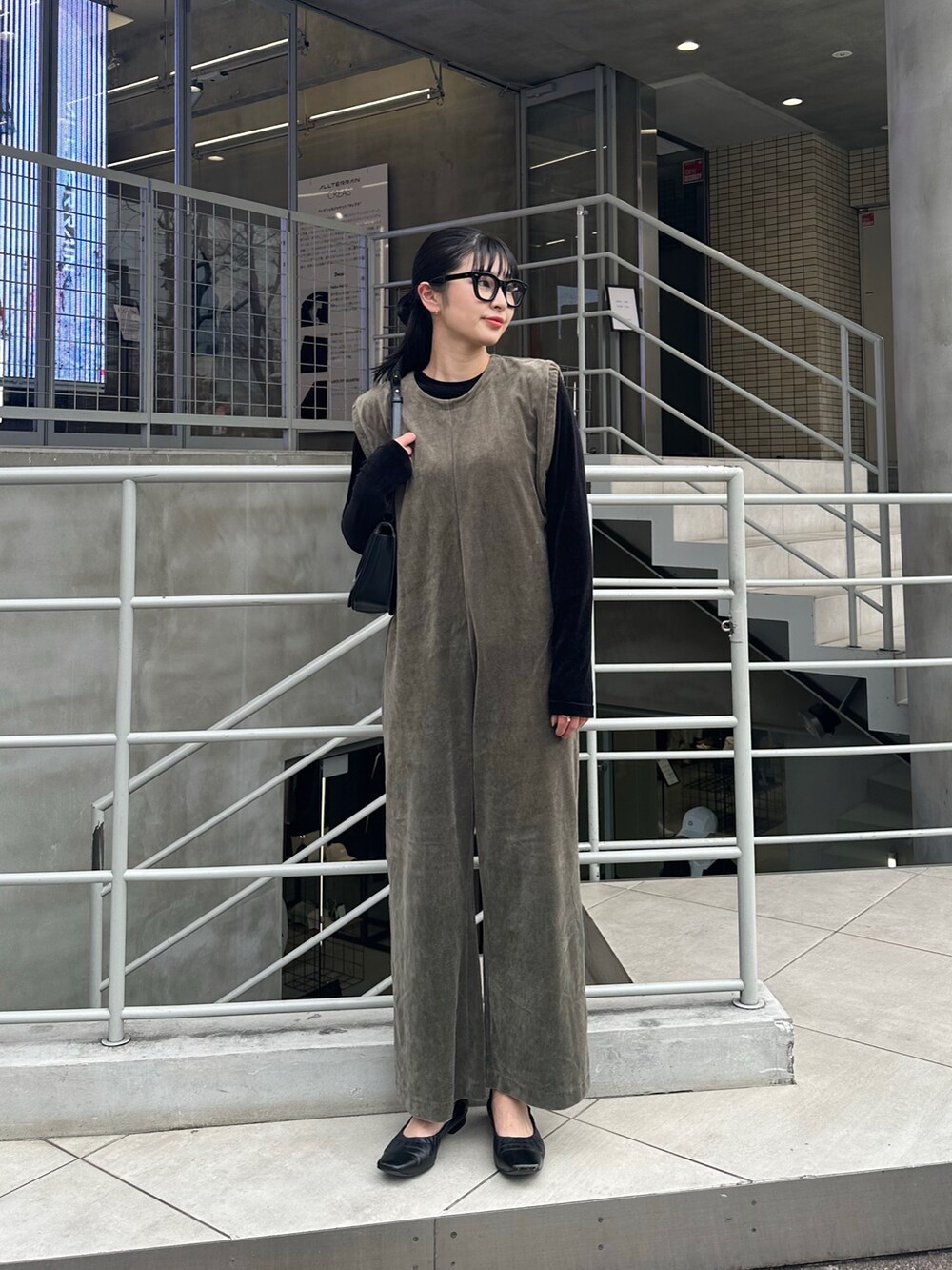 ブラック系のTシャツ/カットソー、ブラック系のパンプス、グリーン系のオールインワン・サロペットを着用したレディースの冬コーディネートの2枚目の写真