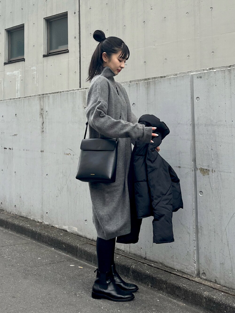 グレー系のワンピース、ブラック系のダウンジャケット/コートを着用したレディースの冬コーディネートの2枚目の写真