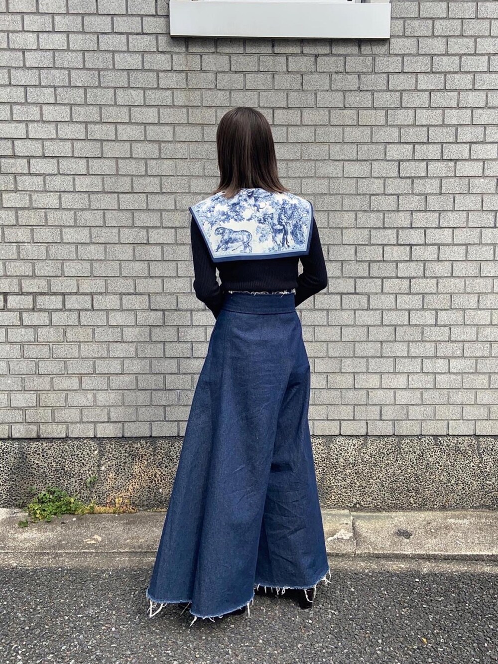 ブルー系のデニムパンツ、ブラウン系のパンプス、ブラック系のニット/セーターを着用したレディースの春コーディネートの3枚目の写真