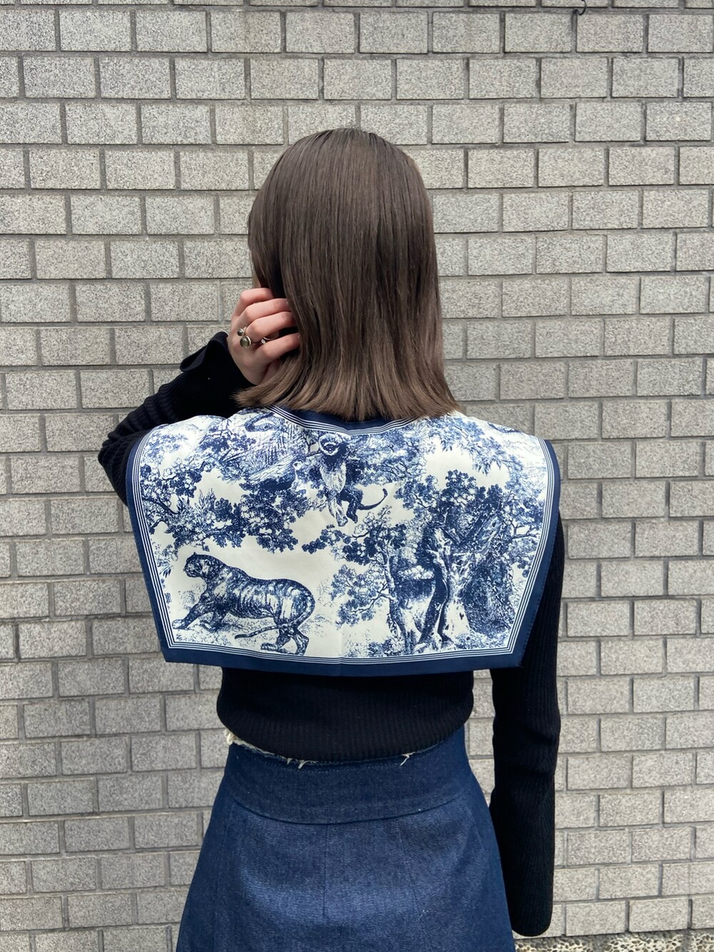 ブルー系のデニムパンツ、ブラウン系のパンプス、ブラック系のニット/セーターを着用したレディースの春コーディネートの4枚目の写真