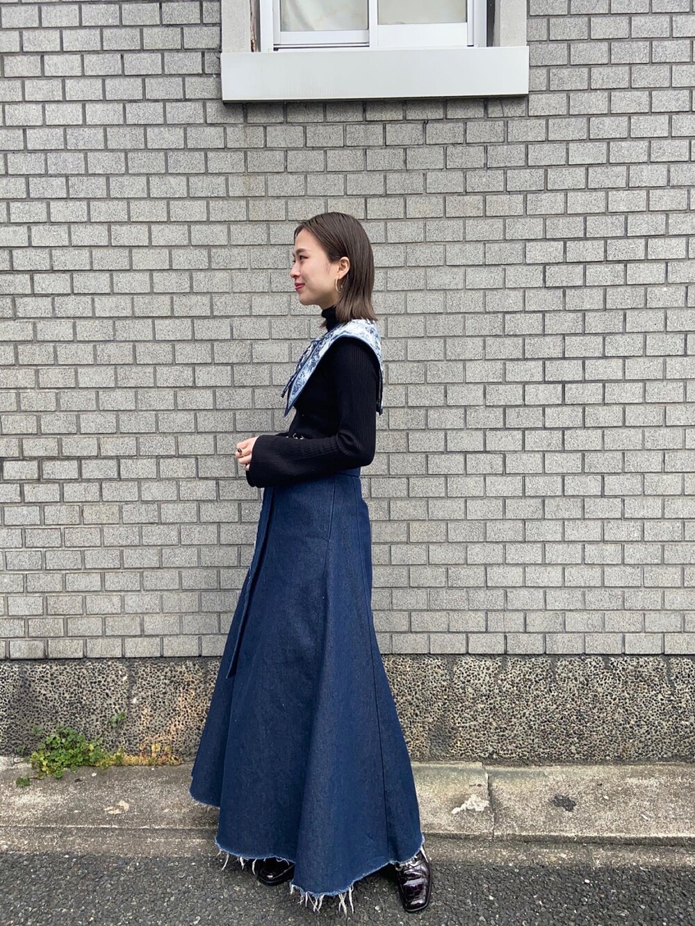 ブルー系のデニムパンツ、ブラウン系のパンプス、ブラック系のニット/セーターを着用したレディースの春コーディネートの2枚目の写真
