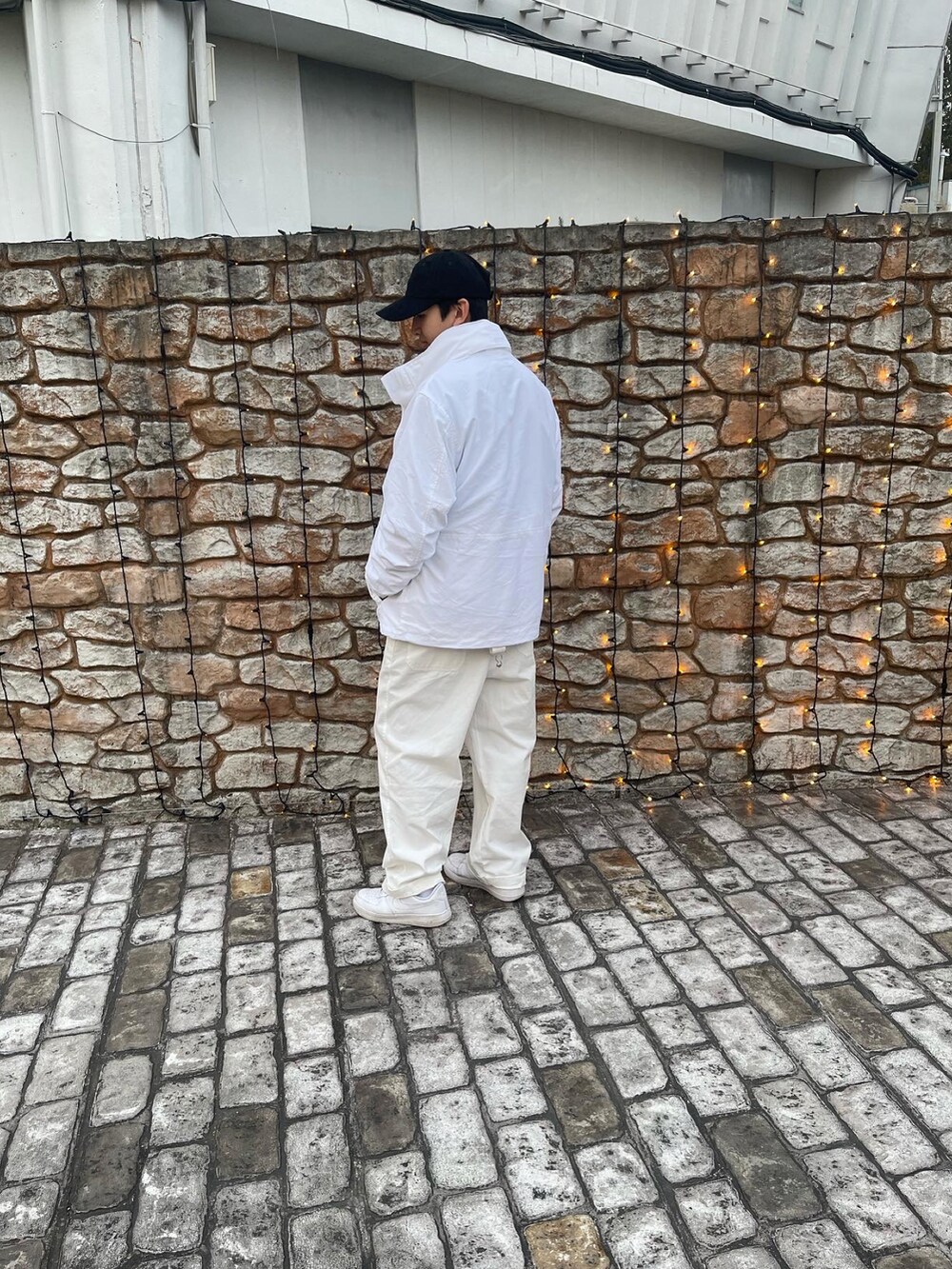 ホワイト系のサロペット/オーバーオール、グレー系のTシャツ/カットソー、ホワイト系のダウンジャケット/コートを着用したメンズの秋コーディネートの2枚目の写真