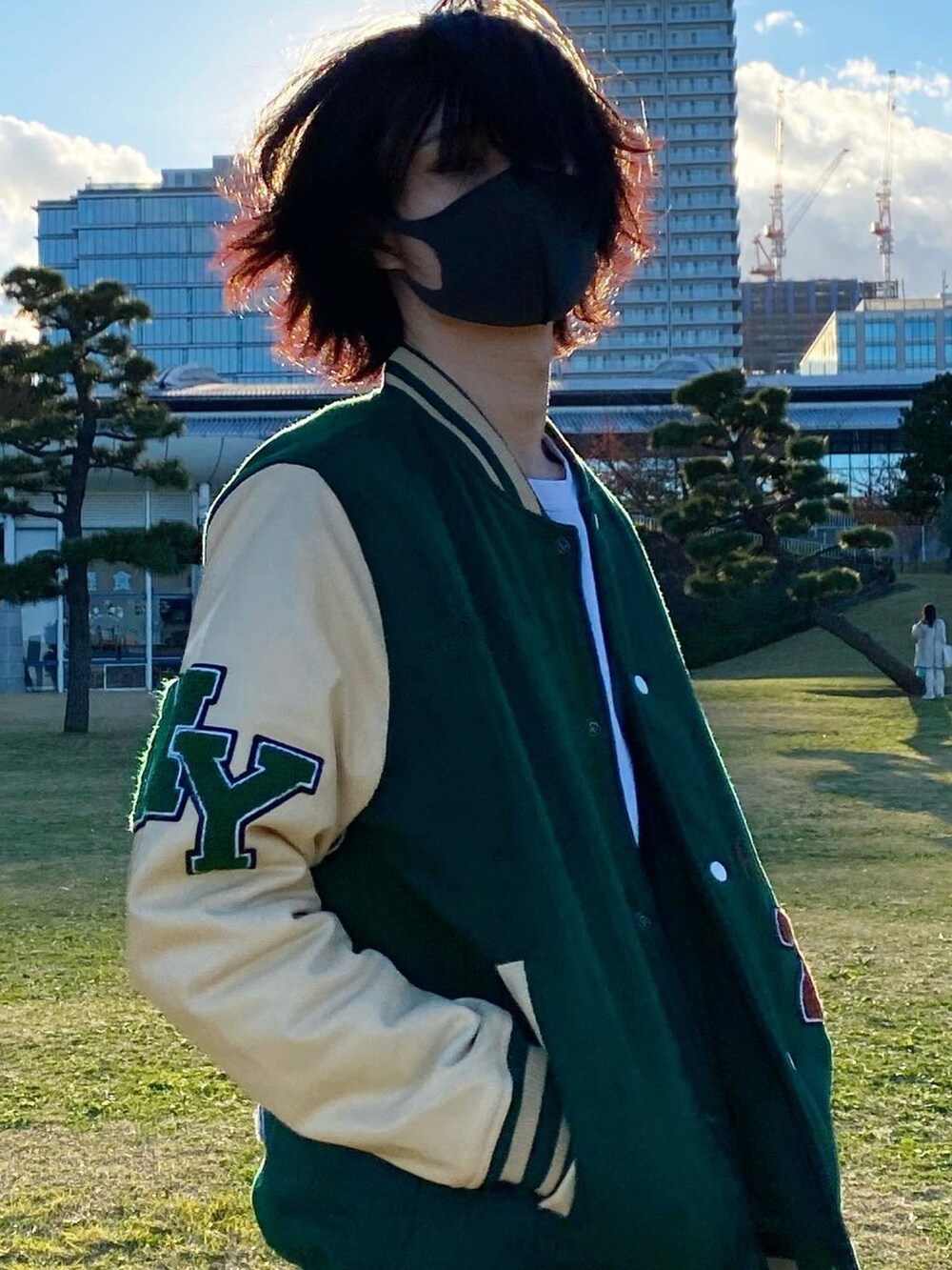 ホワイト系のスニーカー、ホワイト系のデニムパンツ、グリーン系のその他アウターを着用したメンズの冬コーディネートの3枚目の写真