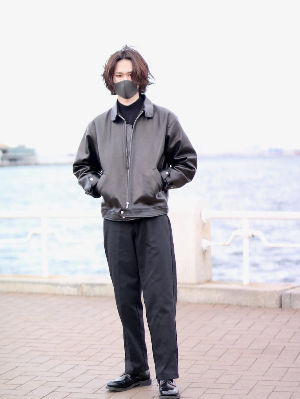 ブラック系のライダースジャケット、ブラック系のドレスシューズ、ブラック系のパンツを着用したメンズの春コーディネートの2枚目の写真