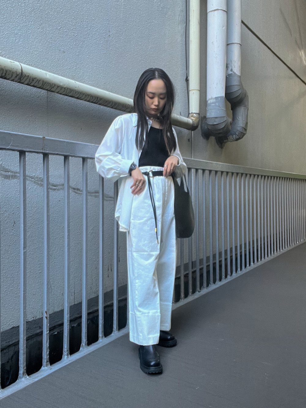 ブラック系のタンクトップ、ブラック系のシャツ/ブラウス、ホワイト系のデニムパンツを着用したレディースの春コーディネートの2枚目の写真