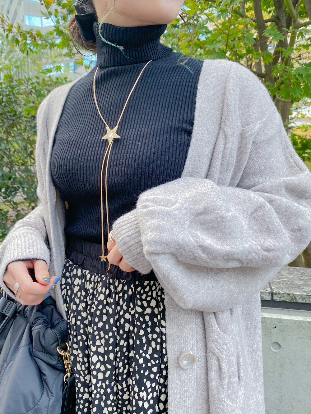 ブラック系のニット/セーター、ブラック系のスカート、ブラック系のブーツを着用したレディースの冬コーディネートの2枚目の写真