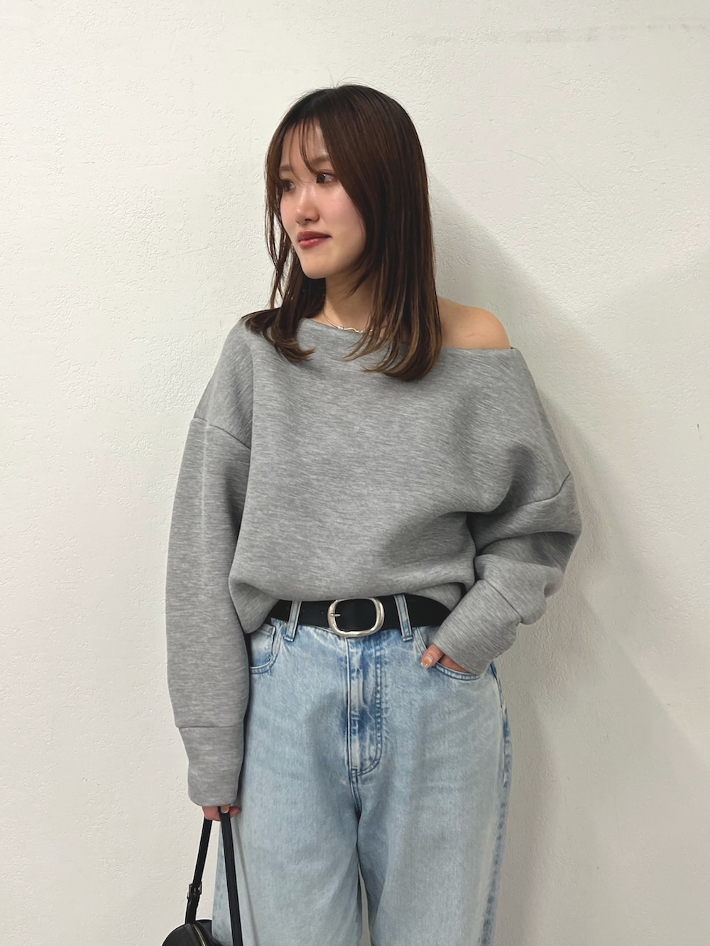 グレー系のTシャツ/カットソー、ブルー系のデニムパンツ、ブラウン系のパンプスを着用したレディースの冬コーディネートの2枚目の写真