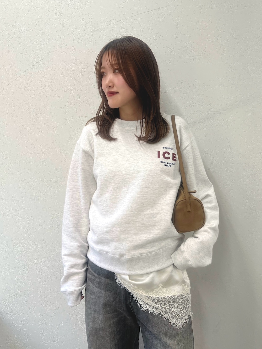 ホワイト系のキャミソール、グレー系のスウェット、グレー系のデニムパンツを着用したレディースの冬コーディネートの3枚目の写真