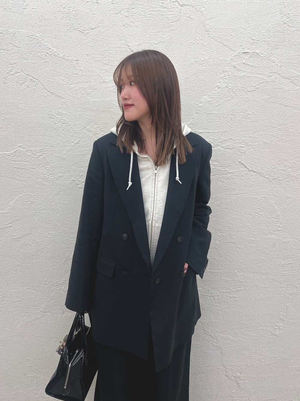 ベージュ系のスウェット、ブラック系のテーラードジャケット、ブラック系のその他パンツを着用したレディースの冬コーディネートの3枚目の写真