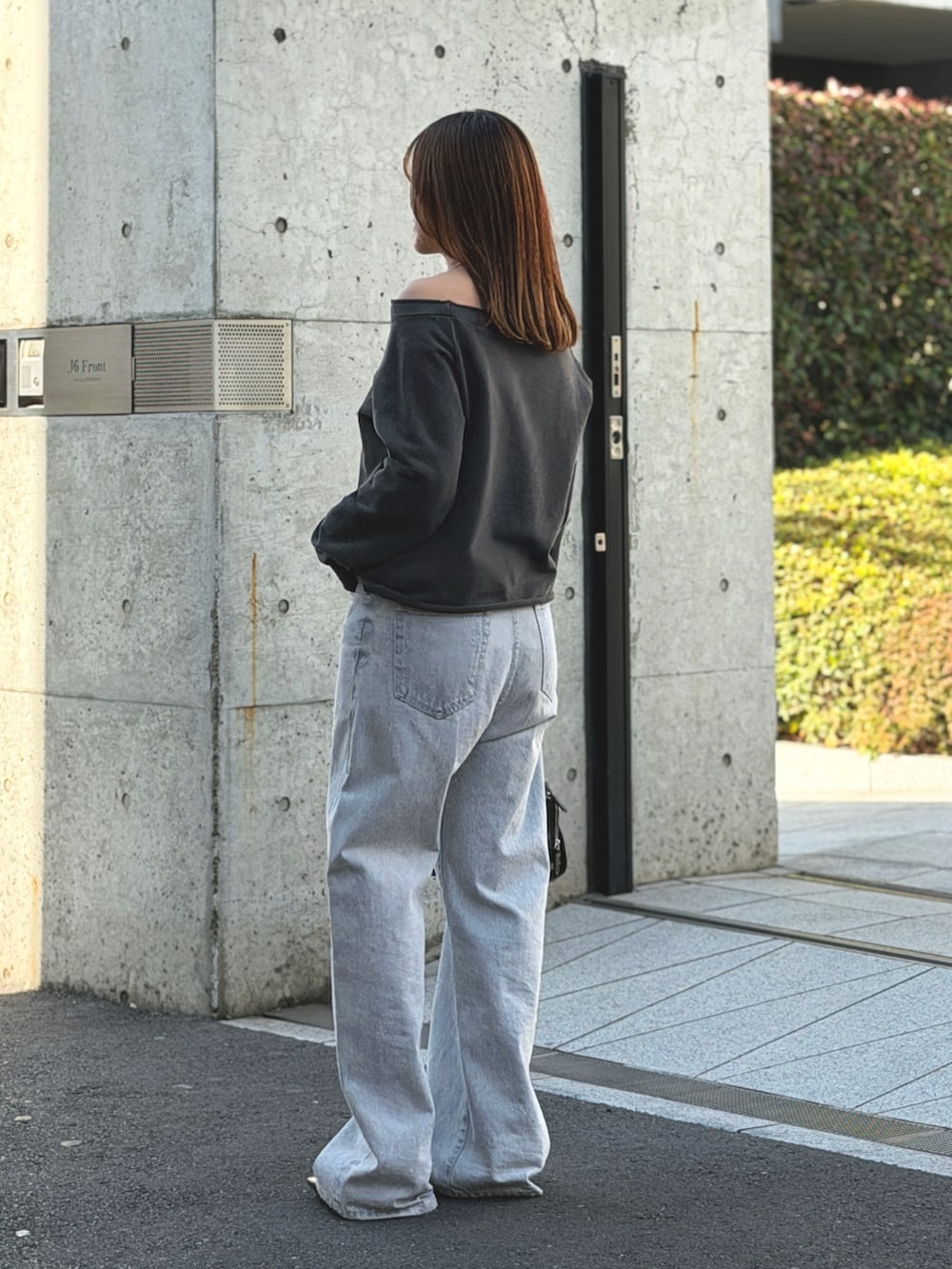 ブルー系のデニムパンツ、グレー系のスウェット、ブラック系のボストンバッグを着用したレディースの冬コーディネートの2枚目の写真