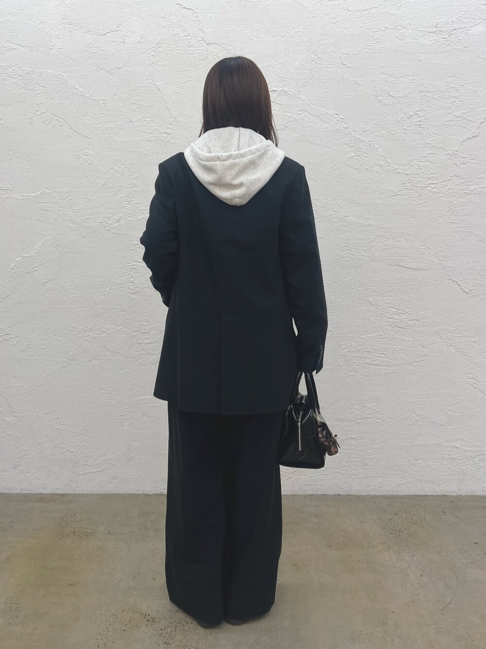 ベージュ系のスウェット、ブラック系のテーラードジャケット、ブラック系のその他パンツを着用したレディースの冬コーディネートの2枚目の写真