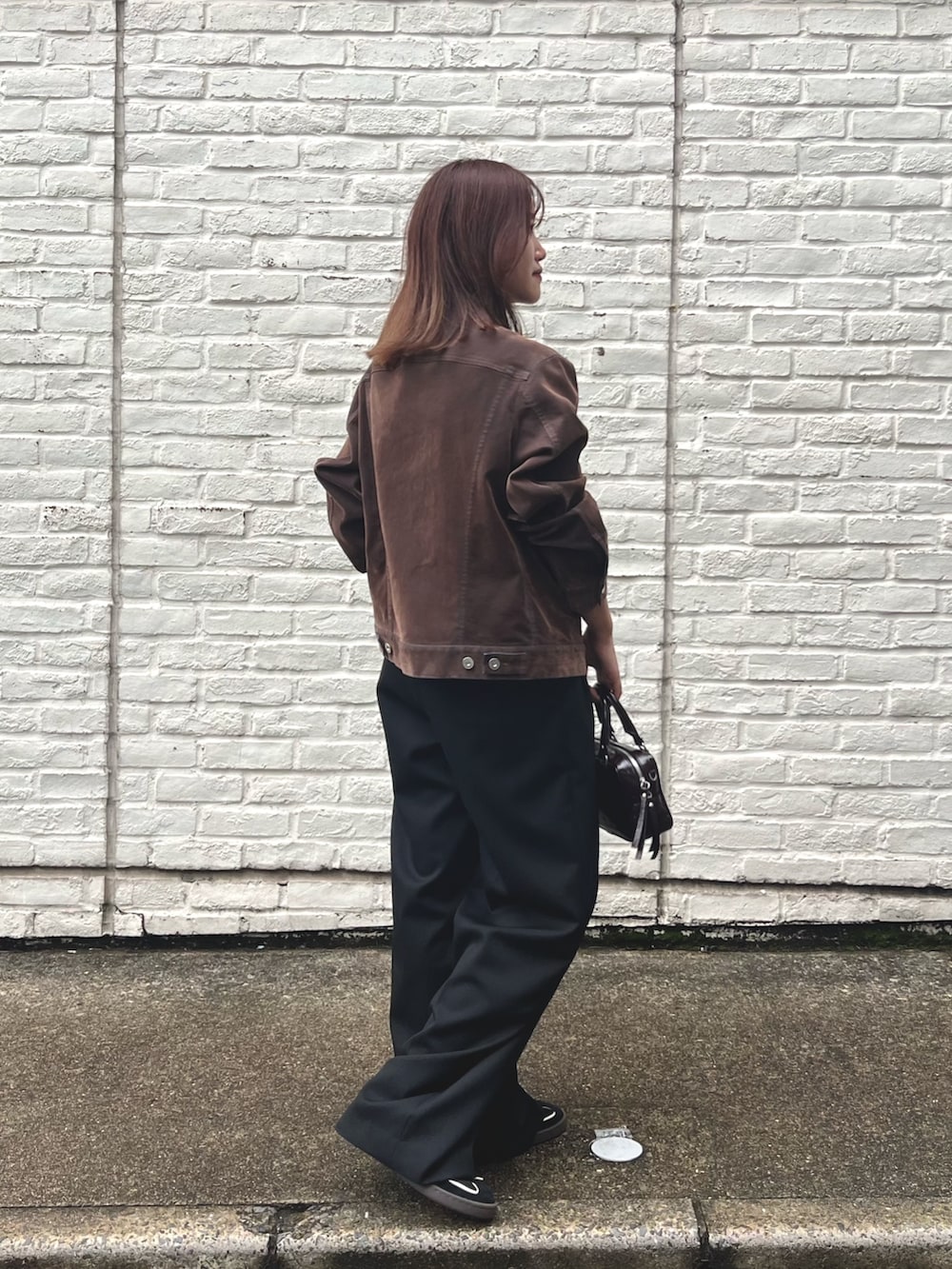 ブラウン系のデニムジャケット、ブラック系のTシャツ/カットソー、ブラック系のその他パンツを着用したレディースの秋コーディネートの2枚目の写真