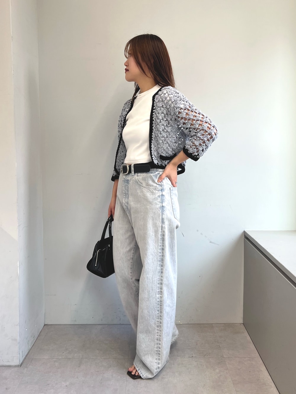 ブルー系のカーディガン/ボレロ、ホワイト系のTシャツ/カットソー、グレー系のデニムパンツを着用したレディースの冬コーディネートの2枚目の写真