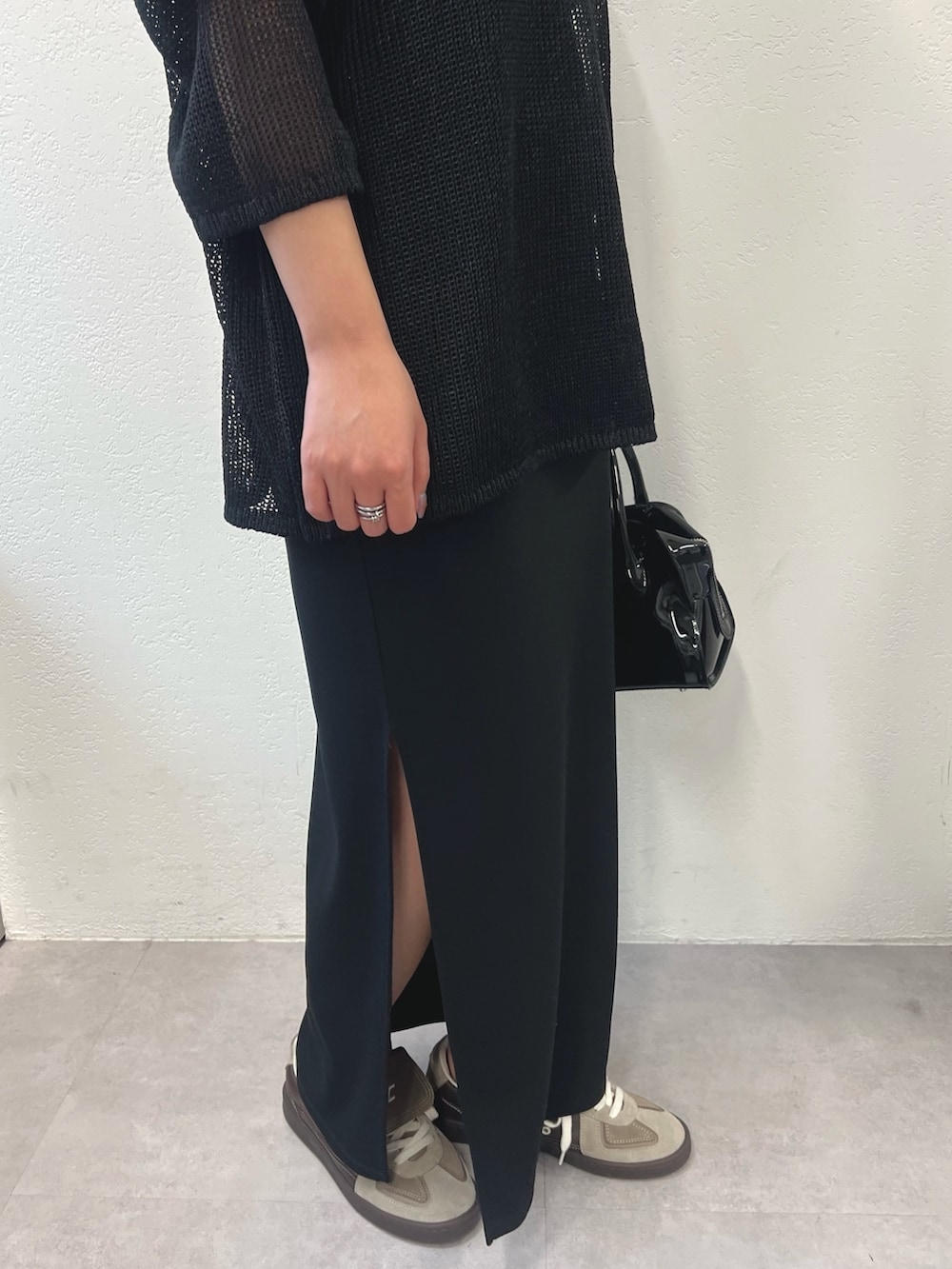 ブラック系のニット/セーター、ブラック系のスカート、ブラック系のボストンバッグを着用したレディースの冬コーディネートの3枚目の写真