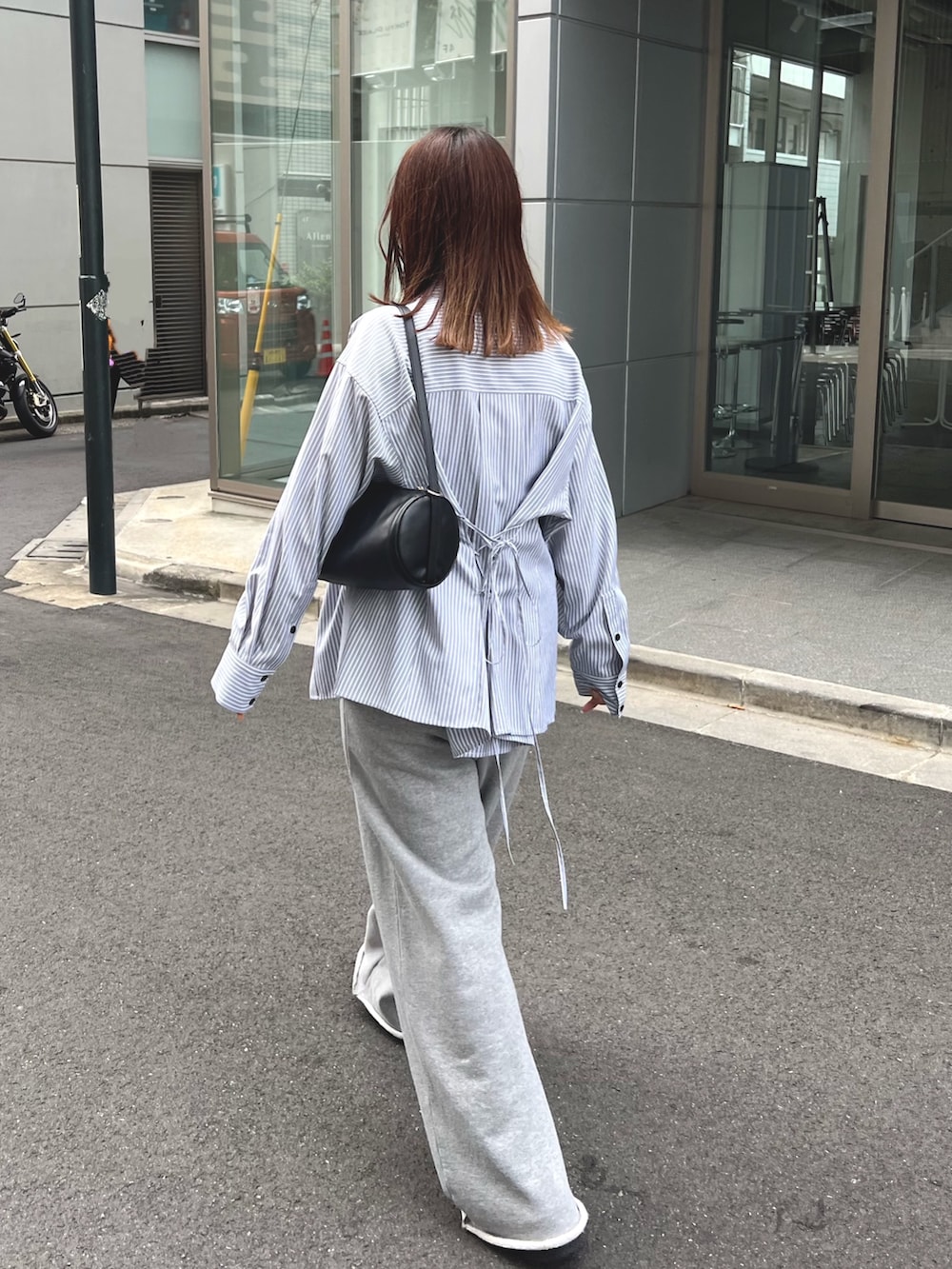 グレー系のスウェットパンツ、グレー系のシャツ/ブラウス、ブラック系のショルダーバッグを着用したレディースの秋コーディネートの2枚目の写真