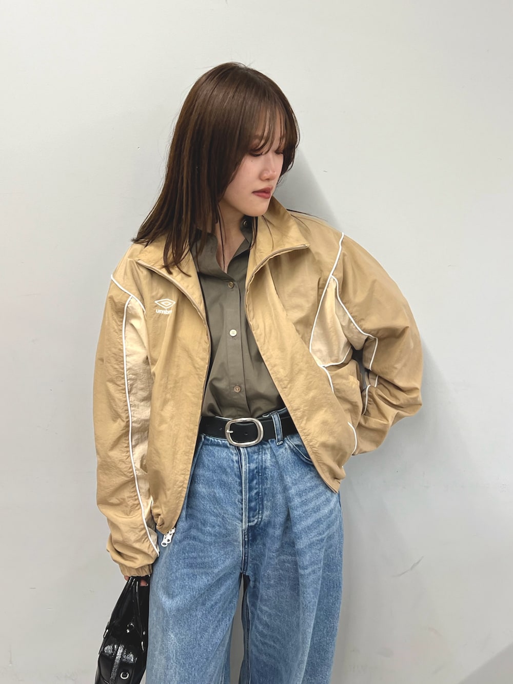 ブラウン系のシャツ/ブラウス、ベージュ系のブルゾン、ブルー系のデニムパンツを着用したレディースの冬コーディネートの2枚目の写真