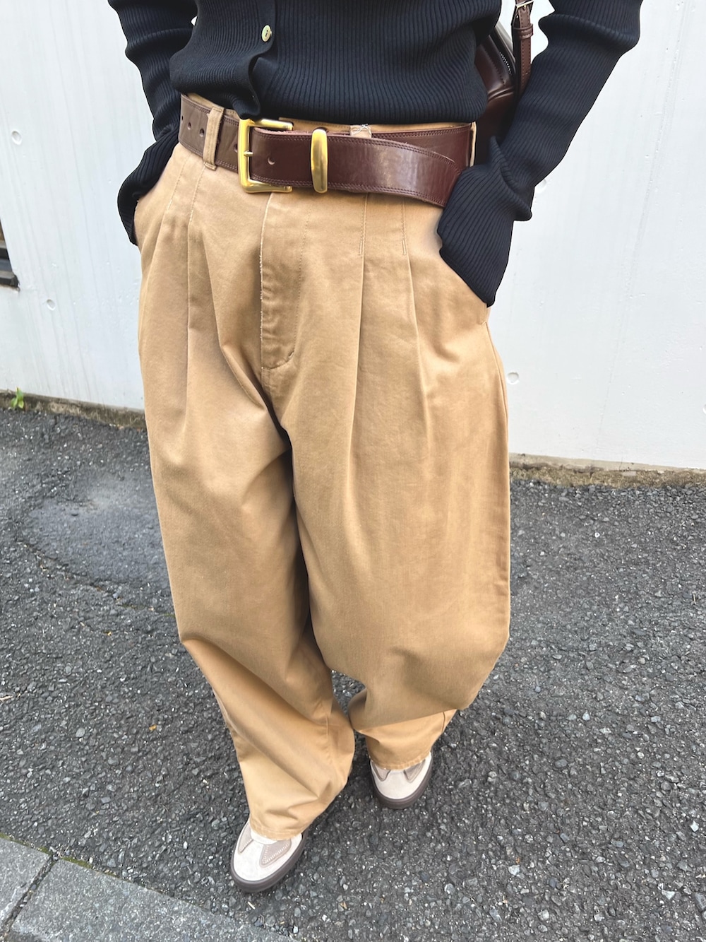 ブラウン系のショルダーバッグ、ベージュ系のチノパンツ、ブラウン系のベルトを着用したレディースの冬コーディネートの3枚目の写真