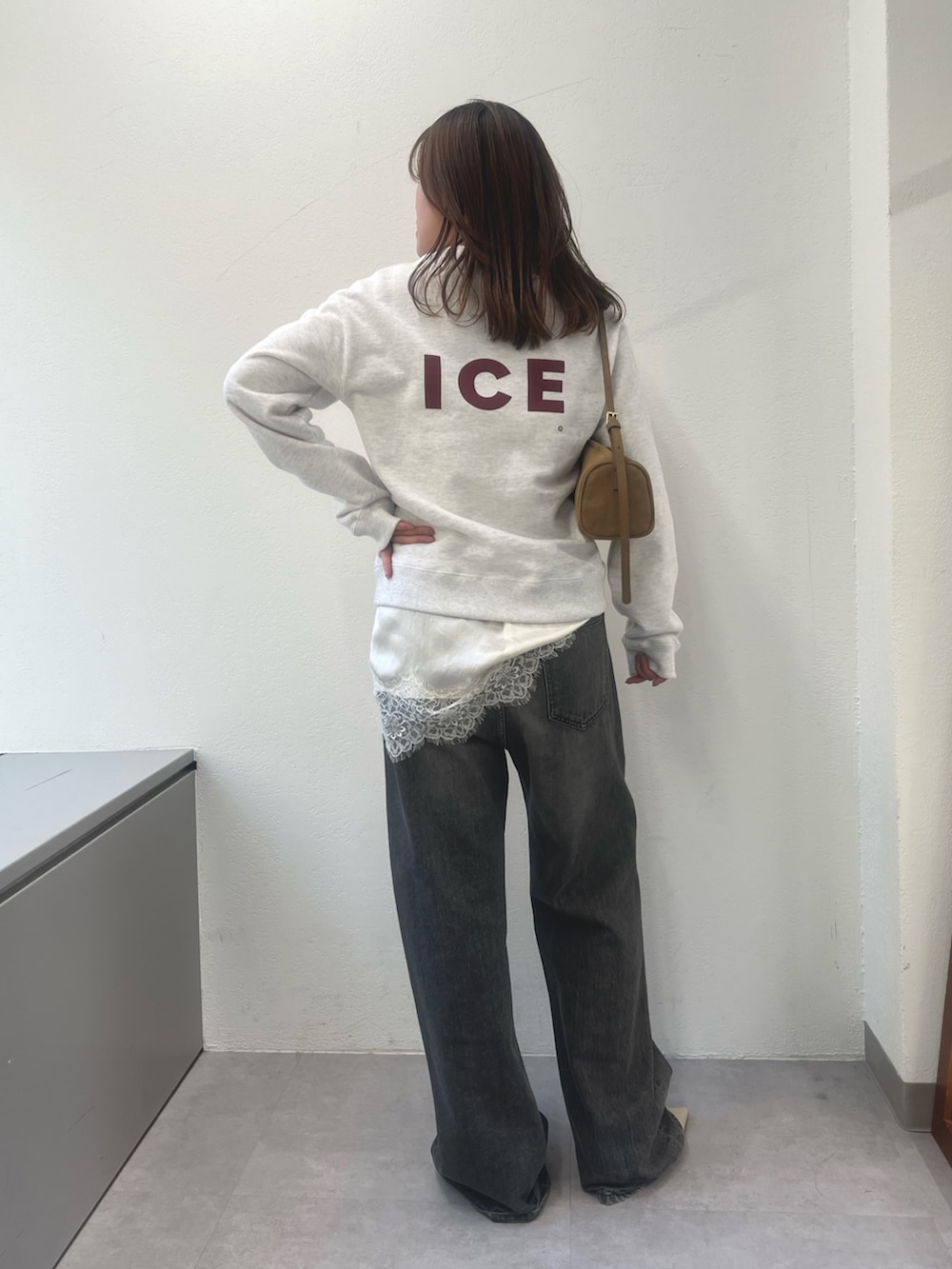 ホワイト系のキャミソール、グレー系のスウェット、グレー系のデニムパンツを着用したレディースの冬コーディネートの2枚目の写真