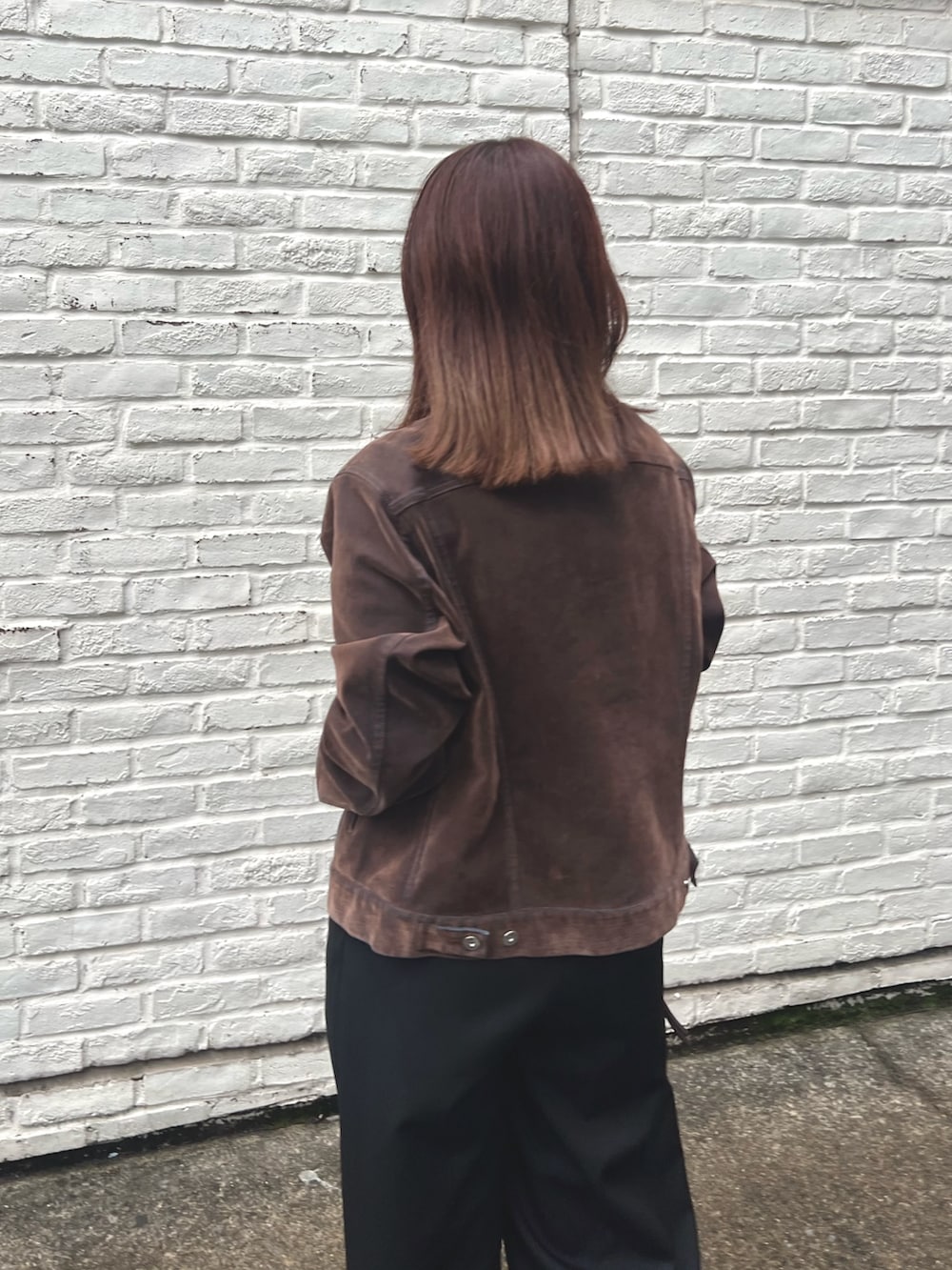 ブラウン系のデニムジャケット、ブラック系のTシャツ/カットソー、ブラック系のその他パンツを着用したレディースの秋コーディネートの4枚目の写真