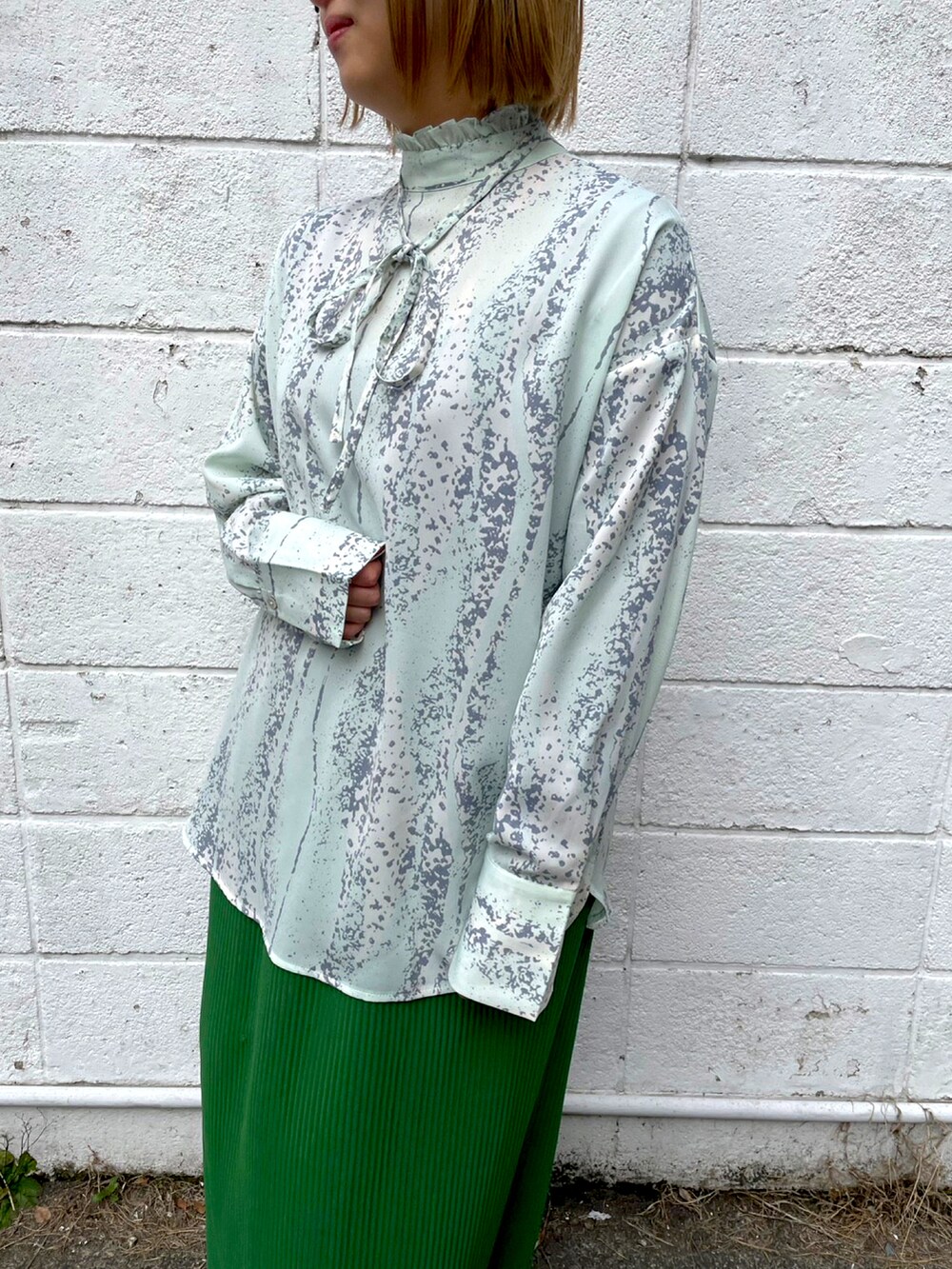 ホワイト系のシャツ/ブラウス、グリーン系のスカートを着用したレディースの冬コーディネートの2枚目の写真