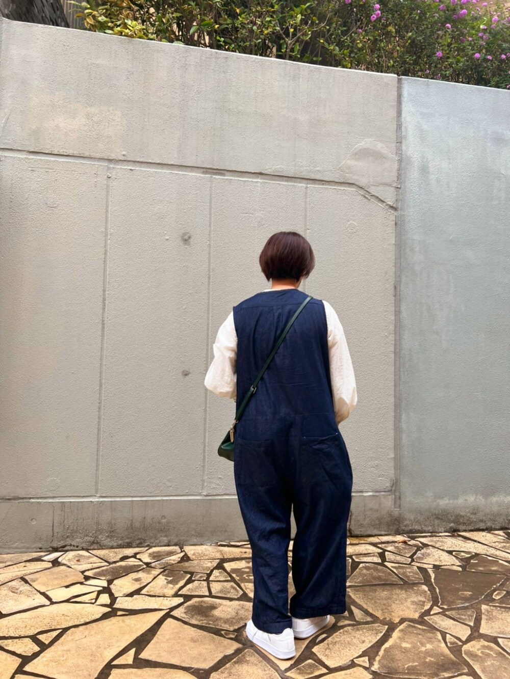 ブルー系のつなぎ/オールインワン、ホワイト系のスニーカー、ホワイト系のシャツ/ブラウスを着用したレディースの春コーディネートの4枚目の写真