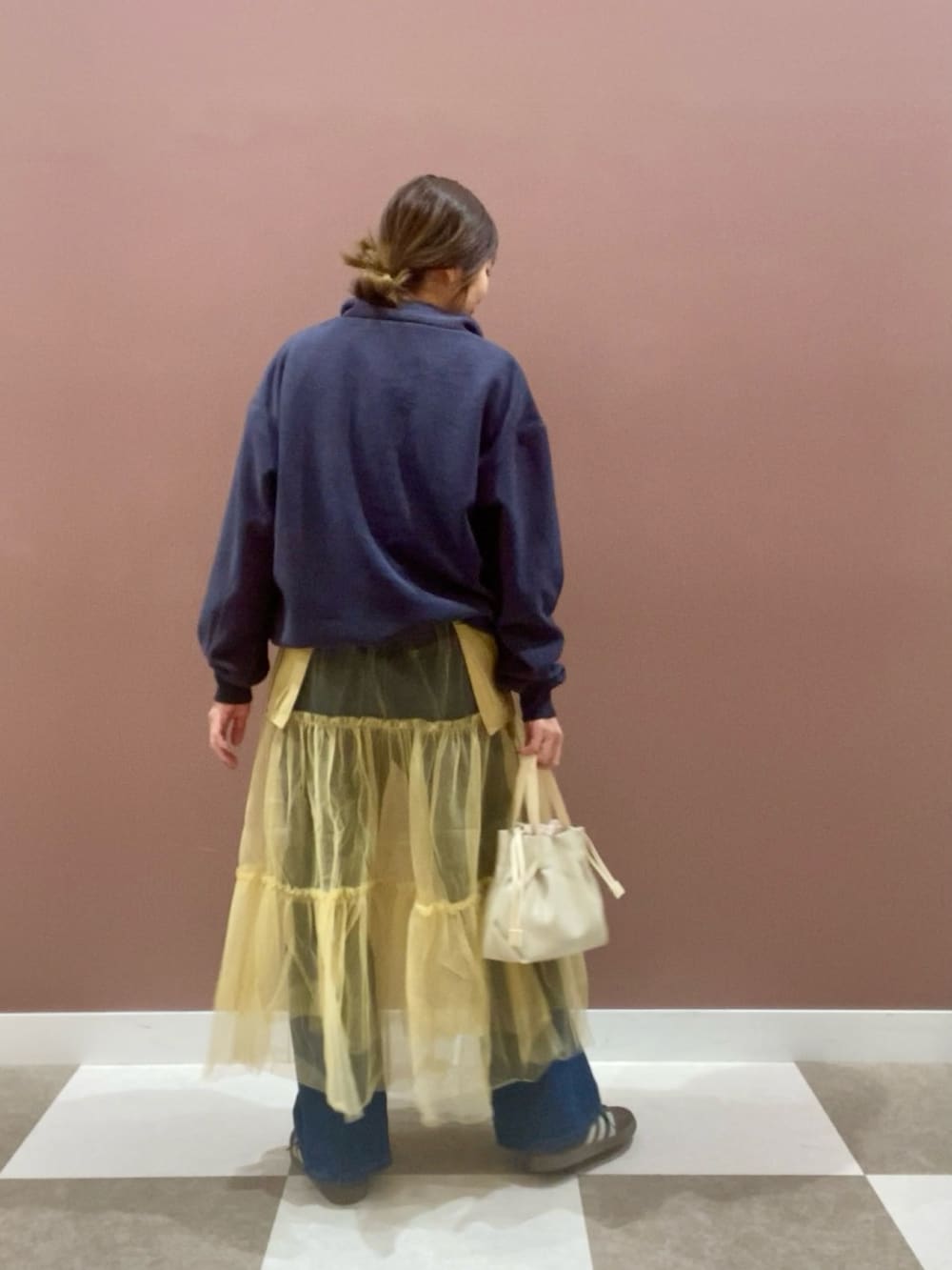 ブルー系のデニムパンツ、ブルー系のその他トップス、イエロー系のスカートを着用したレディースの冬コーディネートの3枚目の写真