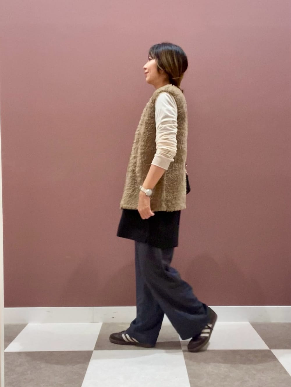 ホワイト系のTシャツ/カットソー、ベージュ系のベスト、グレー系のその他パンツを着用したレディースの秋コーディネートの2枚目の写真