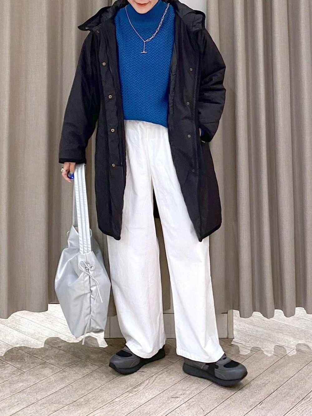 ブラック系のスニーカー、ブラック系のダウンジャケット/コート、その他のショルダーバッグを着用したレディースの冬コーディネートの6枚目の写真