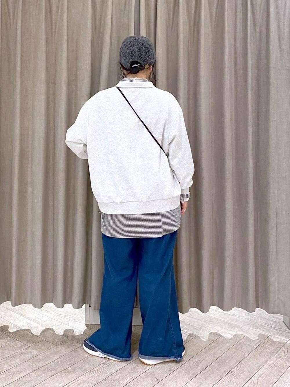ホワイト系のTシャツ/カットソー、ベージュ系のブルゾン、ブルー系のデニムパンツを着用したレディースの秋コーディネートの6枚目の写真
