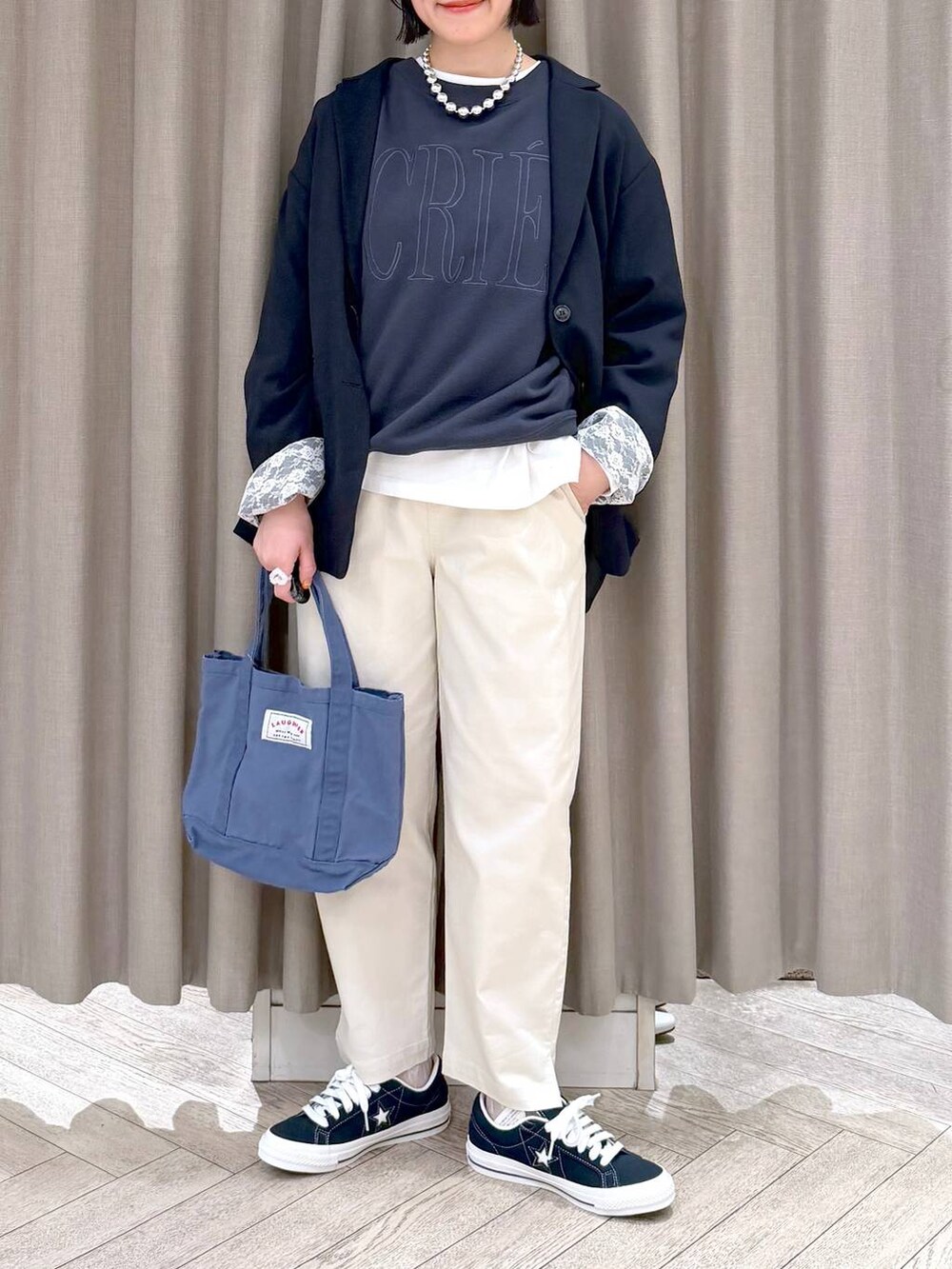ブルー系のトートバッグ、ブルー系のスニーカー、ベージュ系のその他パンツを着用したレディースの春コーディネートの7枚目の写真