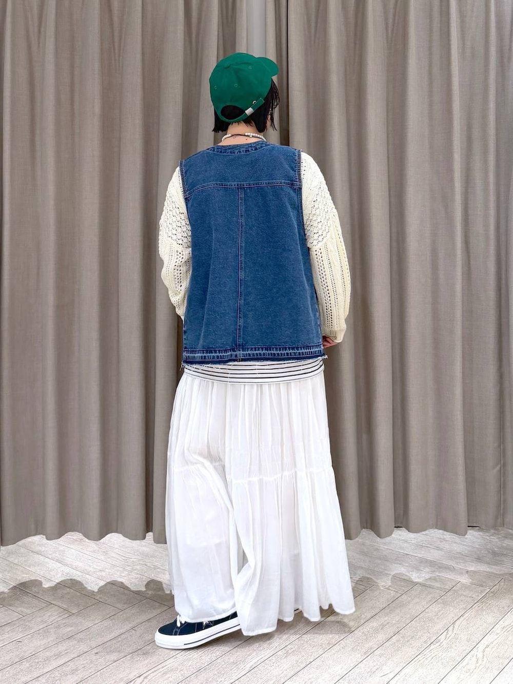 ブルー系のスニーカー、ブルー系のベスト、その他のショルダーバッグを着用したレディースの冬コーディネートの4枚目の写真