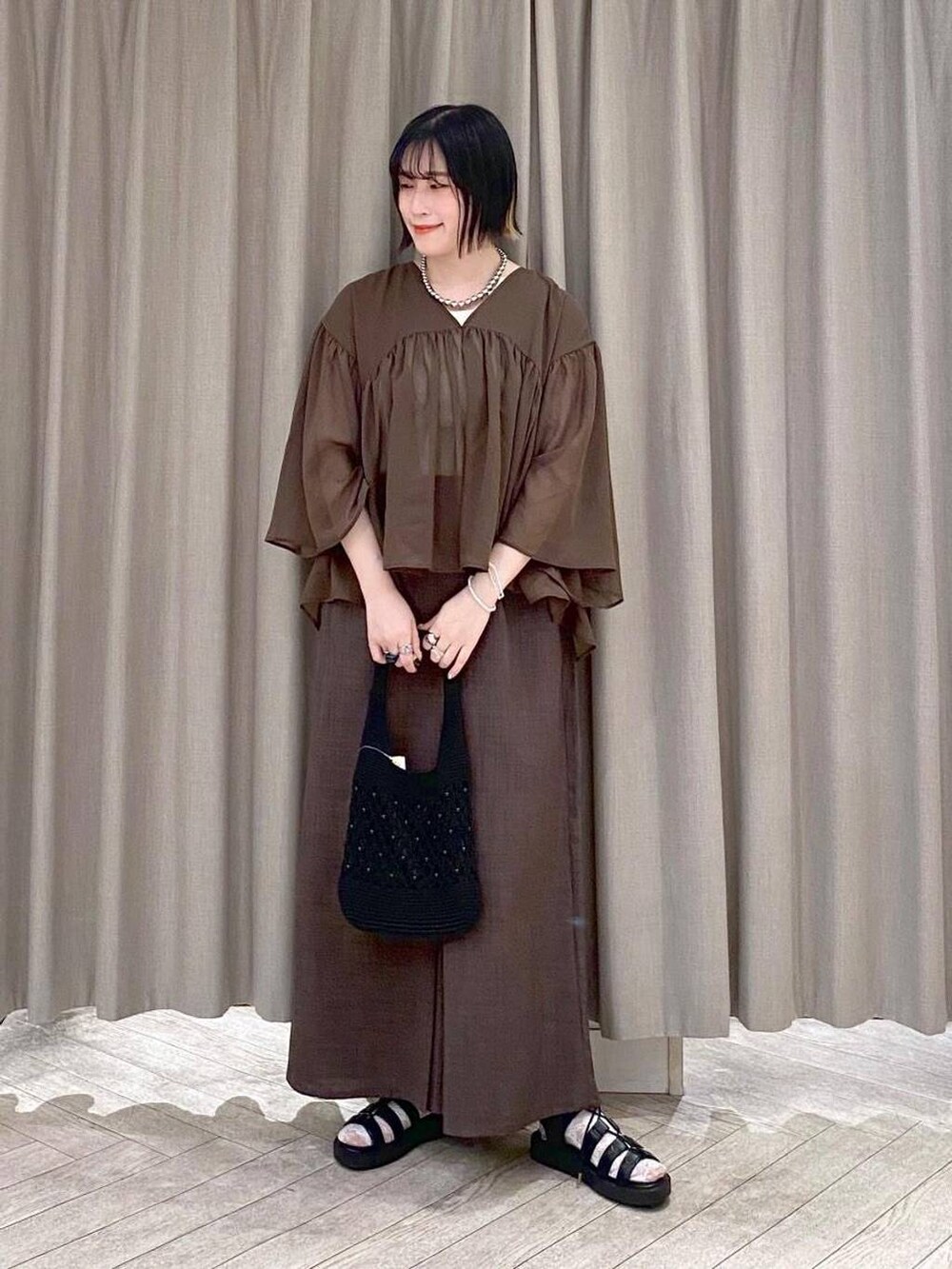ブラウン系のその他パンツ、ブラウン系のシャツ/ブラウス、ブラック系のトートバッグを着用したレディースの夏コーディネートの2枚目の写真