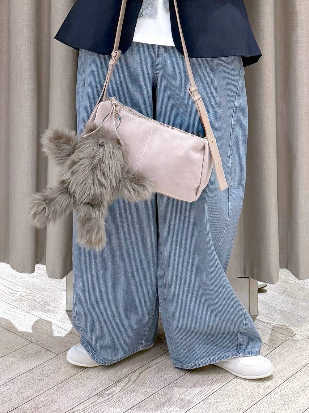 ブルー系のデニムパンツ、ブルー系のテーラードジャケット、グレー系のショルダーバッグを着用したレディースの春コーディネートの7枚目の写真