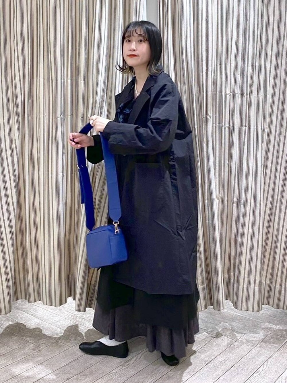 ブラック系のシャツ/ブラウス、ブラック系のジャンパースカート、ブラック系のスカートを着用したレディースの春コーディネートの2枚目の写真