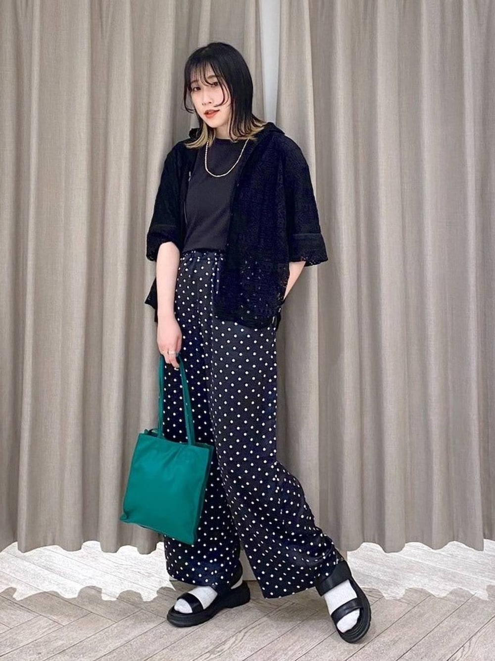 ブラック系のTシャツ/カットソー、ブラック系のサンダル、グリーン系のショルダーバッグを着用したレディースの春コーディネートの9枚目の写真