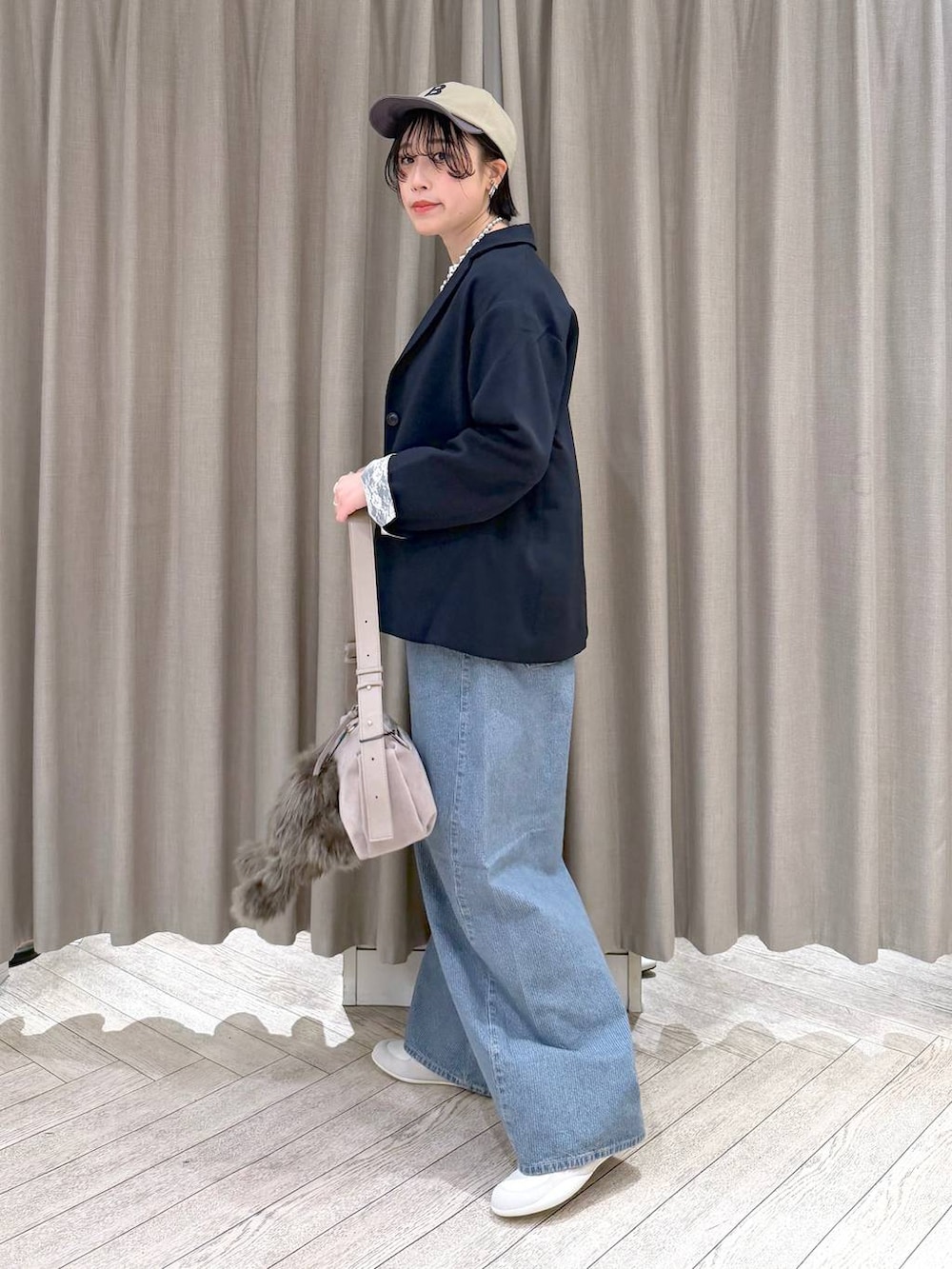 ブルー系のデニムパンツ、ブルー系のテーラードジャケット、グレー系のショルダーバッグを着用したレディースの春コーディネートの3枚目の写真