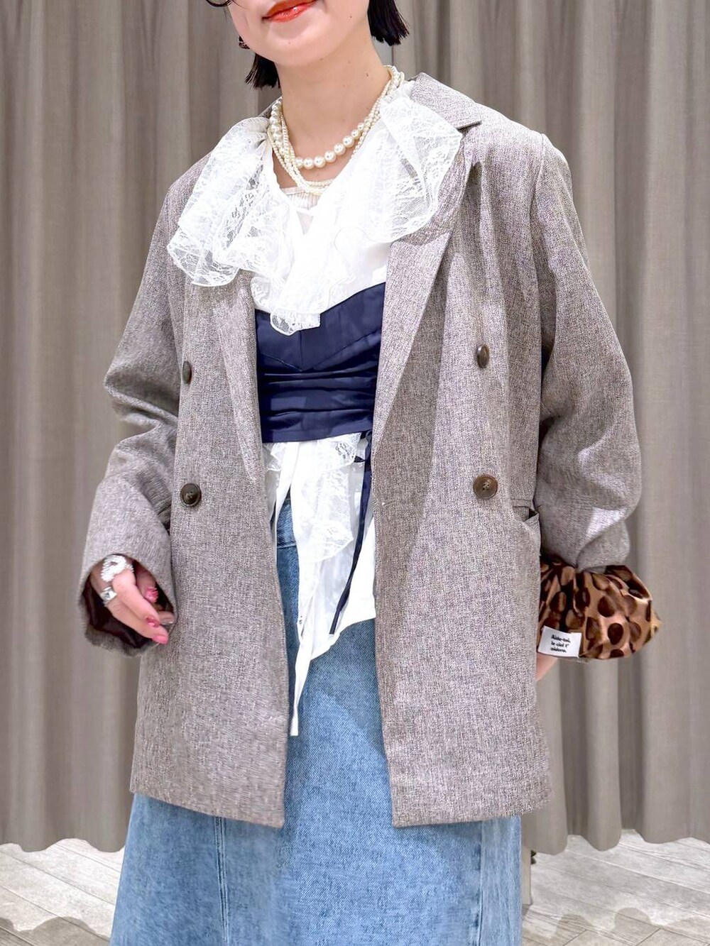 ベージュ系のテーラードジャケット、ブルー系のデニムスカート、ブラウン系のトートバッグを着用したレディースの冬コーディネートの5枚目の写真