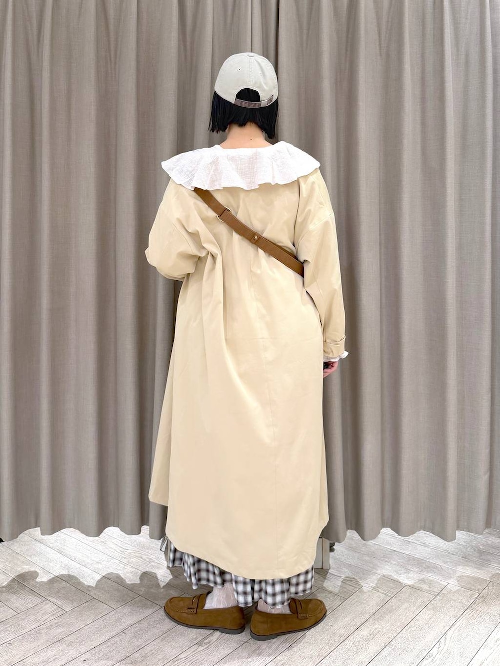 イエロー系のショルダーバッグ、ベージュ系のチェスターコート、イエロー系のローファーを着用したレディースの冬コーディネートの5枚目の写真