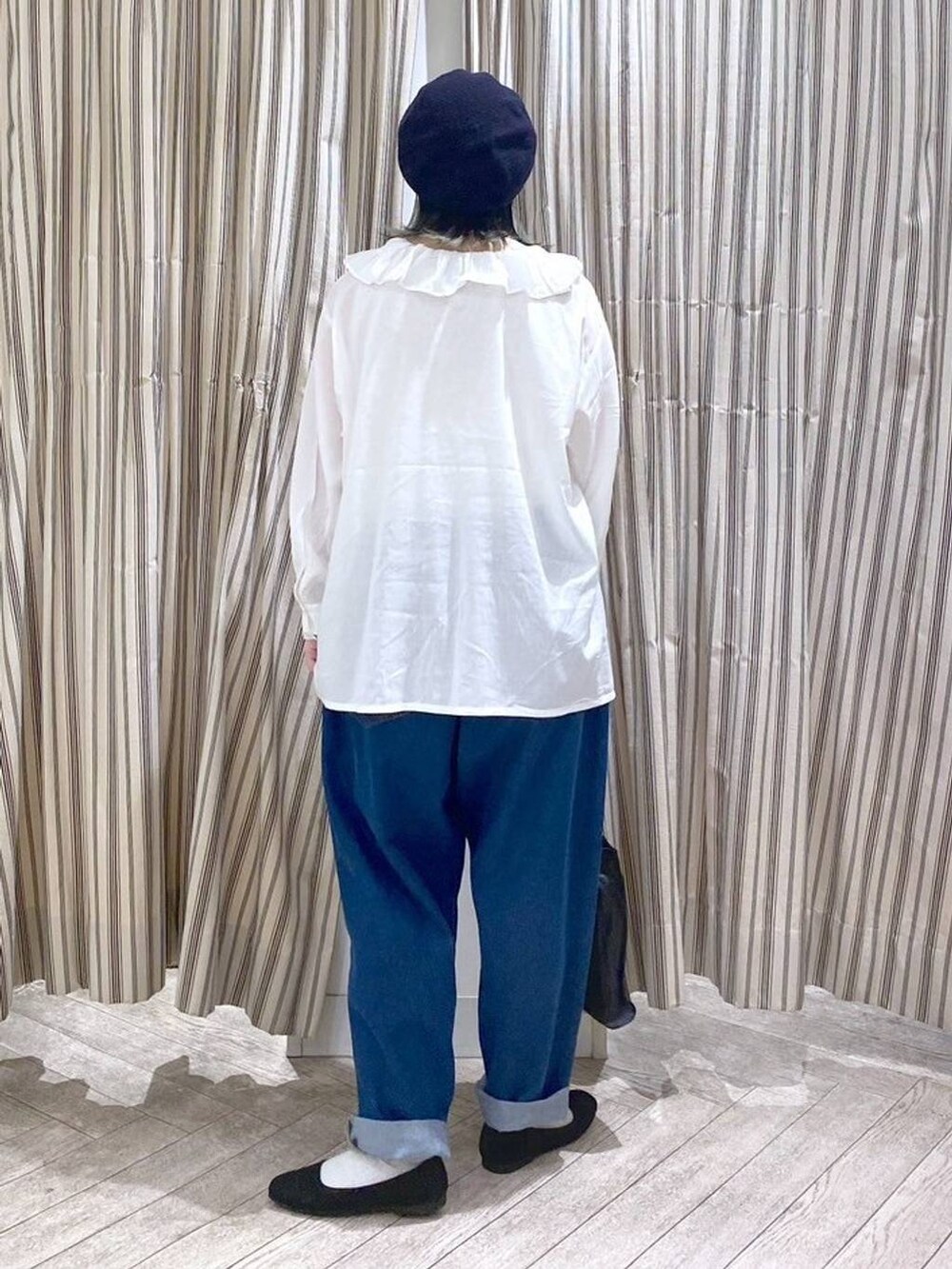 ホワイト系のシャツ/ブラウス、ベージュ系のタンクトップ、ブルー系のデニムパンツを着用したレディースの春コーディネートの8枚目の写真