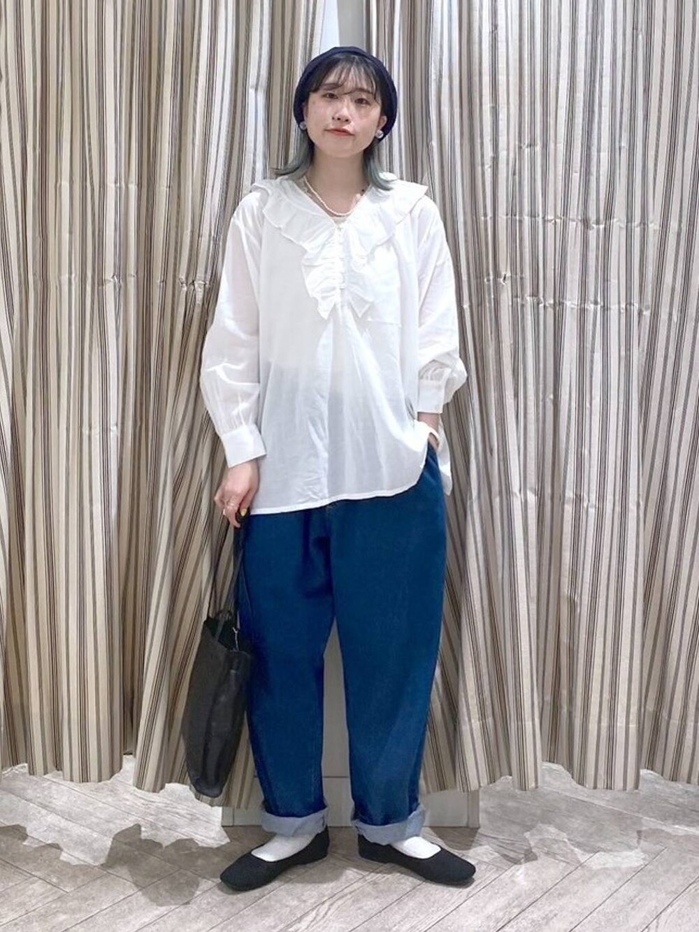 ホワイト系のシャツ/ブラウス、ベージュ系のタンクトップ、ブルー系のデニムパンツを着用したレディースの春コーディネートの6枚目の写真