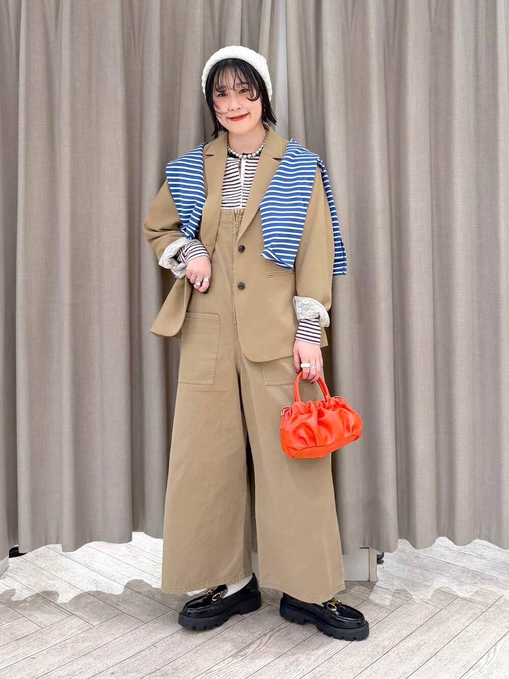 ブラック系のローファー、ベージュ系のサロペット/オーバーオール、オレンジ系のショルダーバッグを着用したレディースの冬コーディネートの9枚目の写真