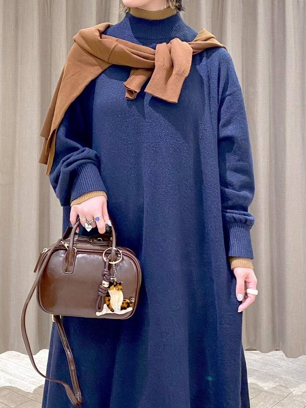 ブラウン系のスカート、イエロー系のカーディガン/ボレロ、ブラウン系のトートバッグを着用したレディースの冬コーディネートの6枚目の写真